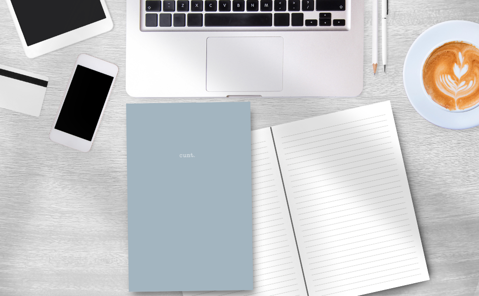 Steel blue cover notebook with cunt. on the front, inside pages, on a desk with a laptop, mobile phone, latte and pens