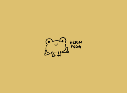 A yellow notebook with a simple black line drawing of a cute little frog on the cover with the words 'Brain frog'.