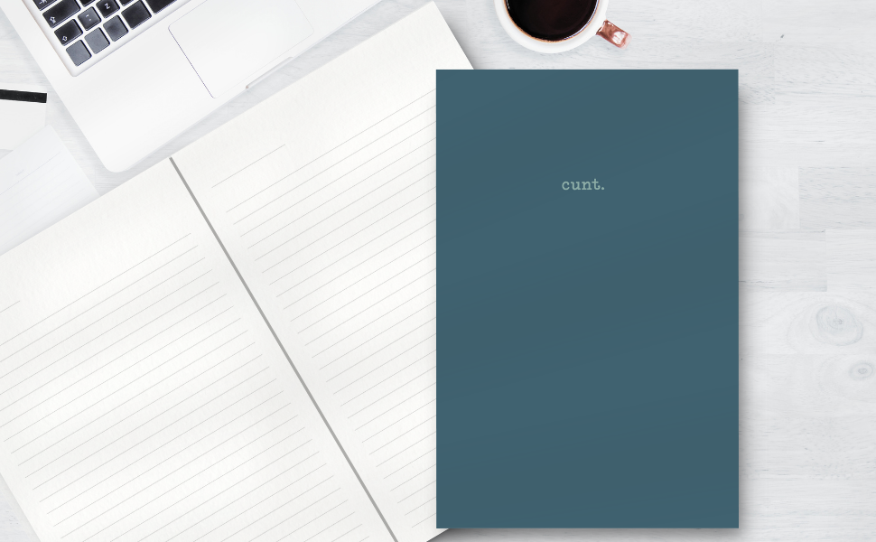 Blue notebook with 'cunt' on a white surface with a laptop and coffee cup.
